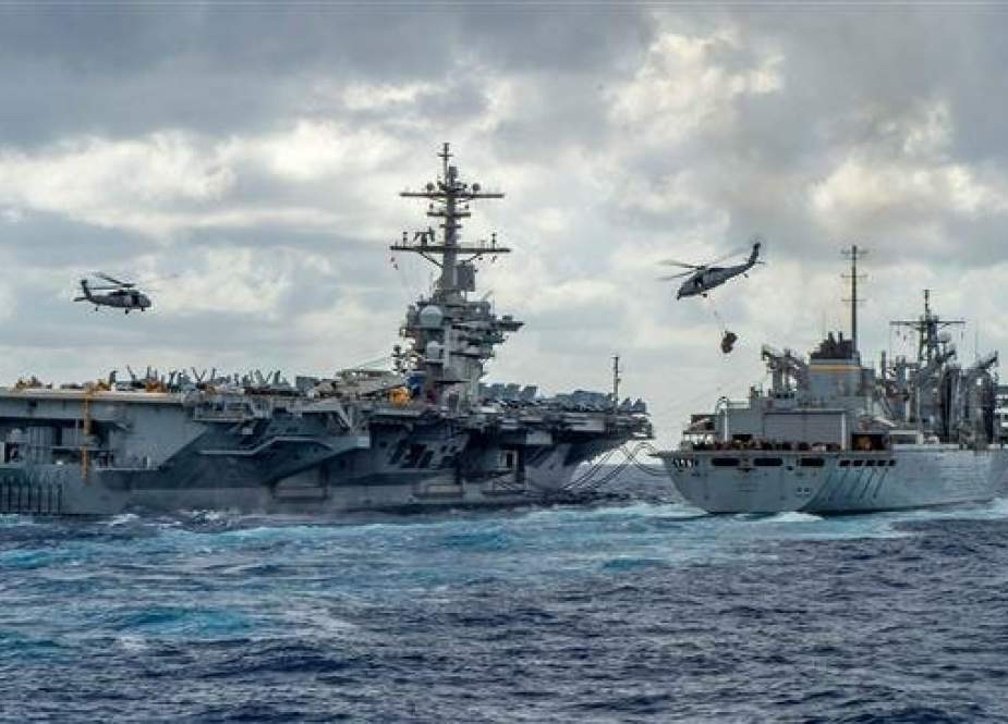 This handout picture released by the US Navy on May 8, 2019 shows the Nimitz-class aircraft carrier USS Abraham Lincoln (CVN 72) while conducting a replenishment-at-sea with the fast combat support ship USNS Arctic (T-AOE 9), while MH-60S Sea Hawk helicopters assigned to the "Nightdippers" of Helicopter Maritime Strike Squadron (HSM) 5, transfer stores between the ships. (Photo via AFP)
