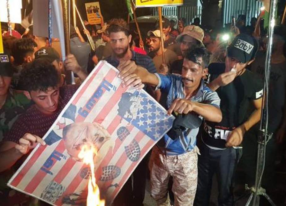 Iraqi protesters set on fire an American flag outside the Bahrain embassy in Baghdad