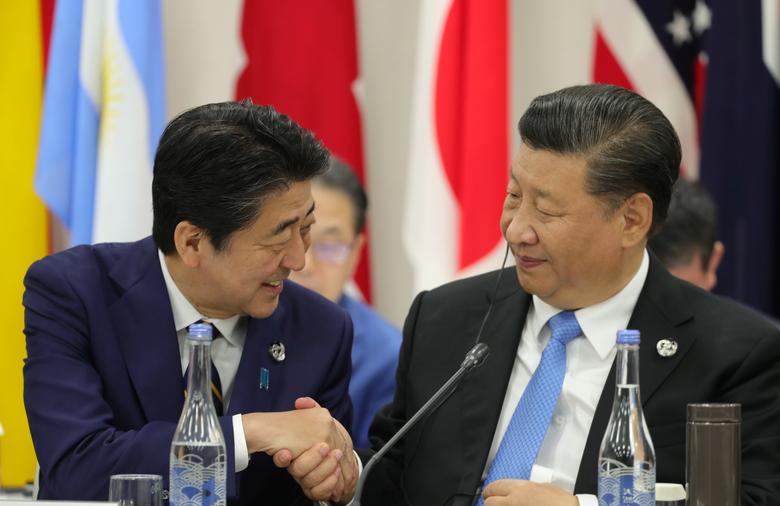 Japan's Prime Minister Shinzo Abe shakes hands with China's President Xi Jinping during the G20 summit in Osaka, Japan, June 28