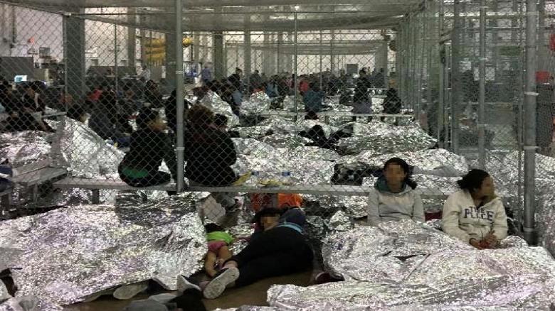 An overcrowded fenced area holding families at a Border Patrol Centralized Processing Center is seen in a still image from video in McAllen, Texas, on June 11, 2019. Picture pixelated at source