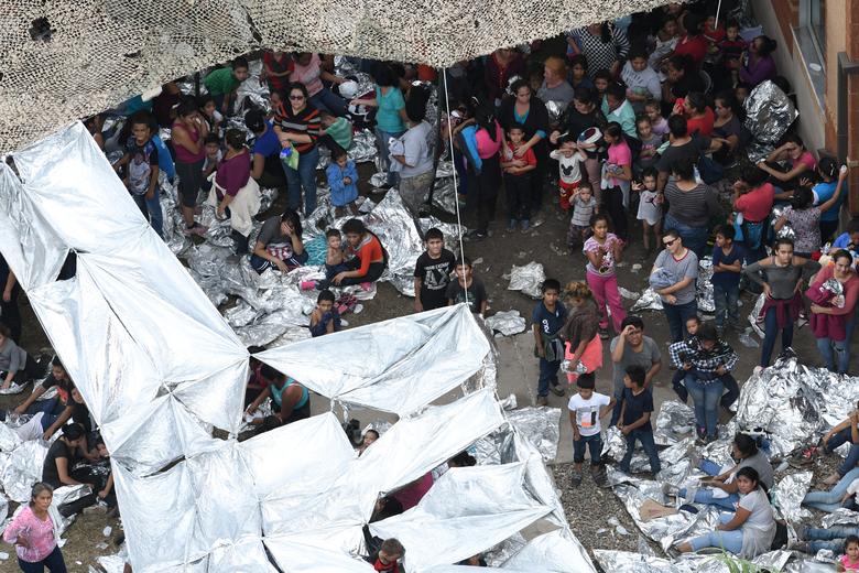 Migrants are seen outside the Border Patrol McAllen Station in a makeshift encampment in McAllen, Texas, May 15, 2019
