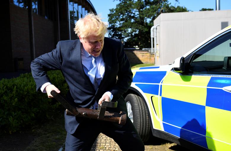 Boris Johnson, a leadership candidate for Britain's Conservative Party, holds a battering ram as he visits the Thames Valley Police Training Centre in Reading, Britain, July 3, 2019