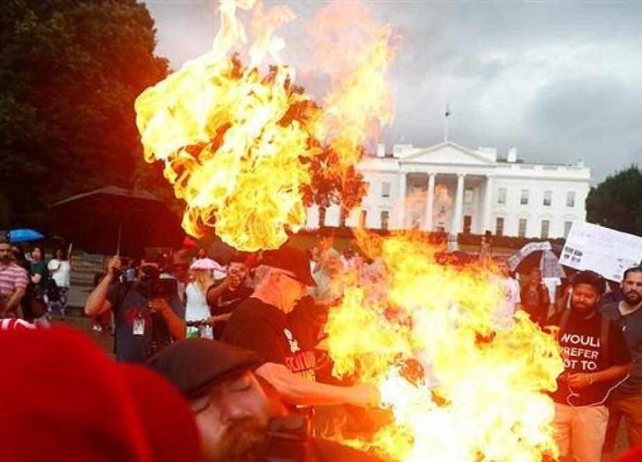 Demonstrators burn a national flag in front of the White House in Washington, DC.jpg