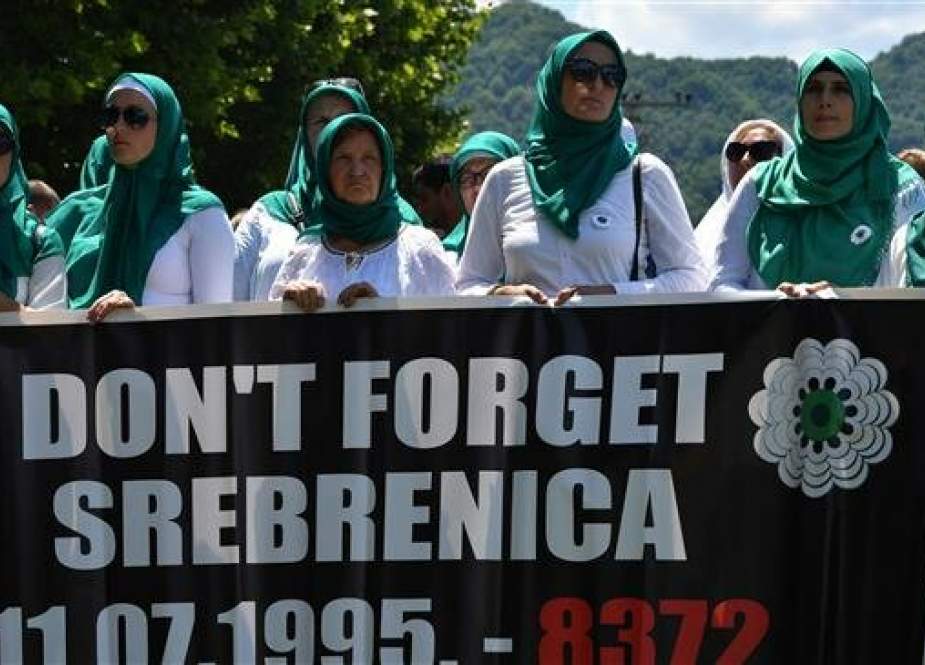 Muslim women hold a banner commemorating the 1995 Srebrenica massacre during s burial ceremony at the Potocari cemetery near the Eastern-Bosnian town of Srebrenica on July 11, 2019. (Photo by AFP)
