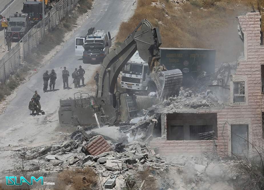 An Israeli machinery demolishes a Palestinian building in the village of Sur Baher on the outskirts of the occupied East Jerusalem al-Quds on July 22, 2019.