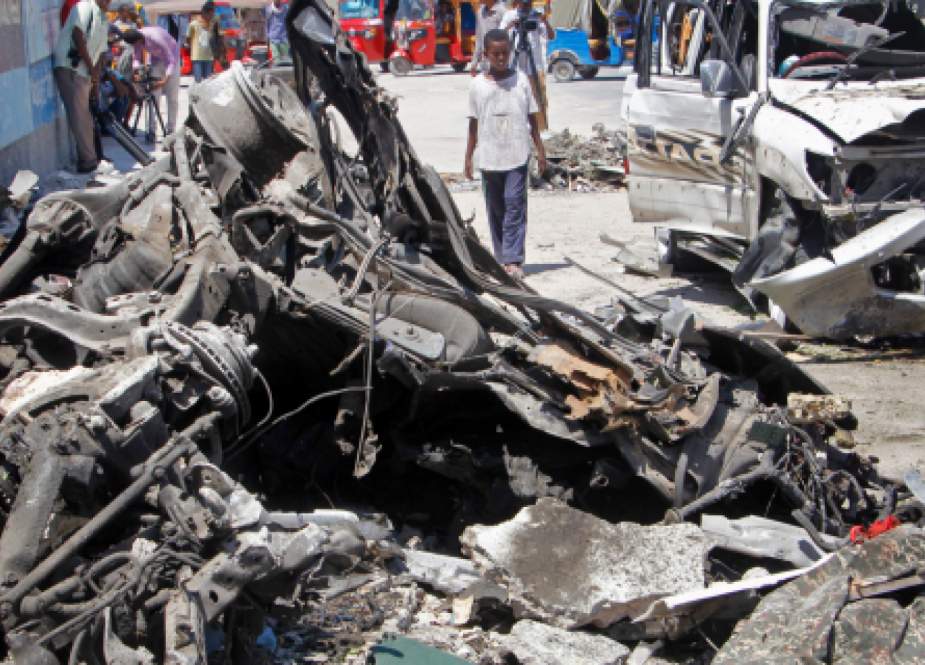 People look at the scene of a car bomb attack near a security checkpoint in the Somali capital of Mogadishu