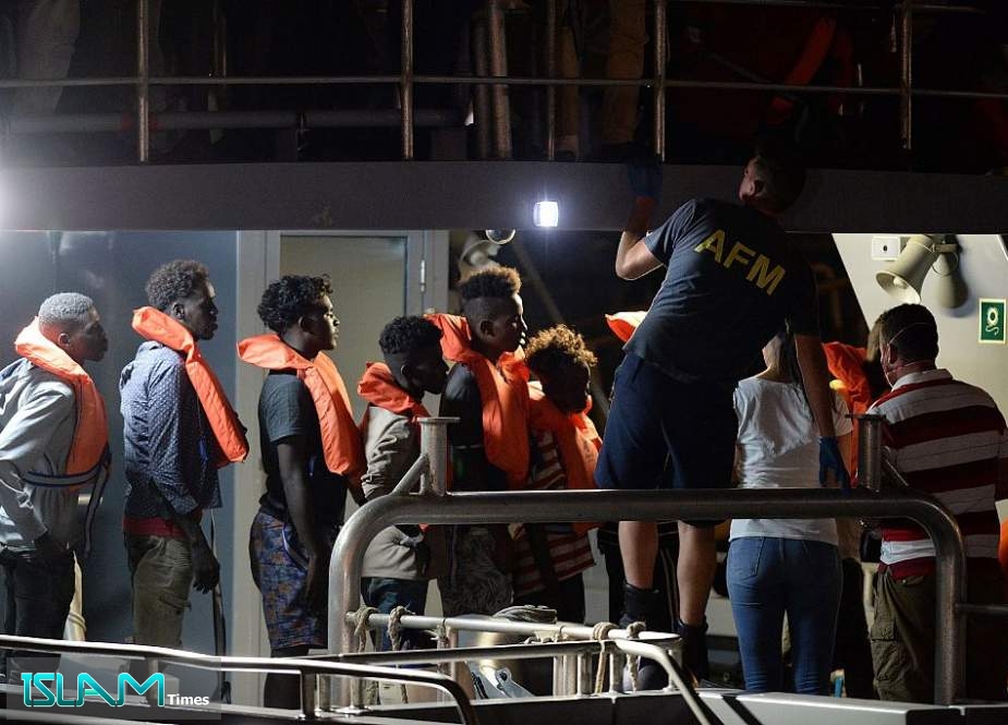 Migrants queue as they are brought into Haywharf, in Valletta, by the armed forces of Malta after being transferred onto the Maltese patrol boat on July 7, 2019