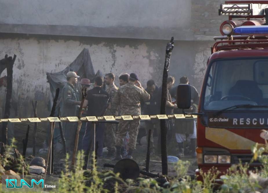 Pakistani soldiers and officers survey the site after a military aircraft on a training flight crashed in a built-up area in the garrison city of Rawalpindi on July 30, 2019.