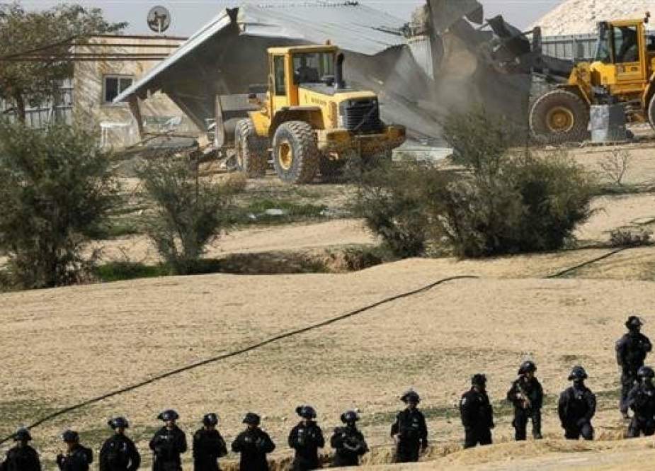 Israeli policemen stand guard as bulldozers demolish homes in the Bedouin village of Umm al-Hiran.jpg