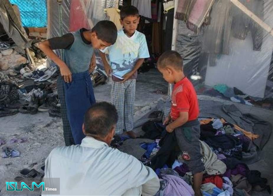 Displaced Syrian children try second-hand clothes in preparation for the Muslim religious holiday of Eid al-Adha at a camp in Kafr Lusin near the border with Turkey in the northern part of Syria’s Idlib Province, on August 9, 2019.