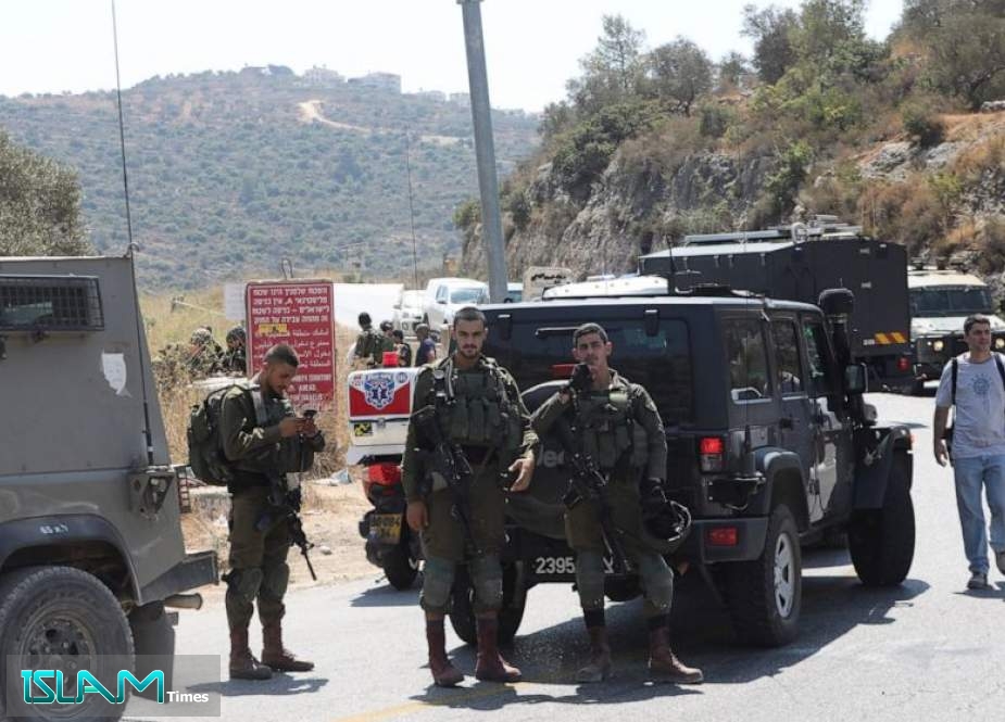 Israeli soldiers stand at the site where a bomb was reportedly thrown from a passing car near the Israeli settlement of Dolev in the occupied West Bank on August 23, 2019