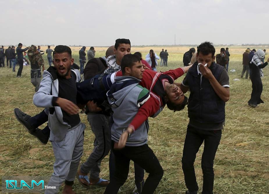 Palestinian youths carry a wounded protester following a demonstration east of Khan Yunis