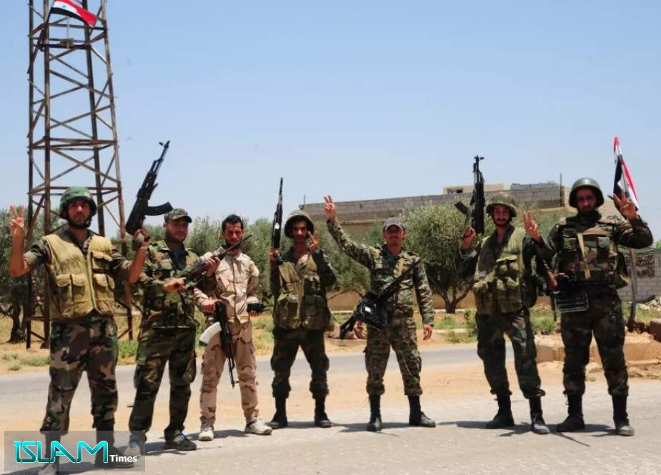 Syrian army soldiers flash the V for victory sign as they pose for a photograph in Khan Sheikhoun town, northwestern province of Idlib