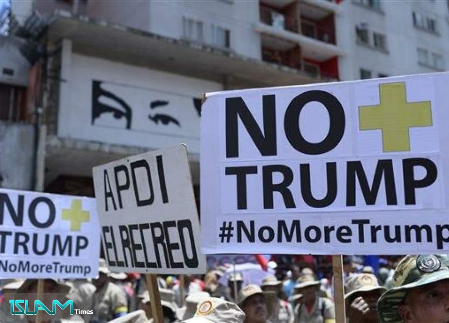 Protesters hold banners reading "No More Trump" during a rally in support of Venezuela
