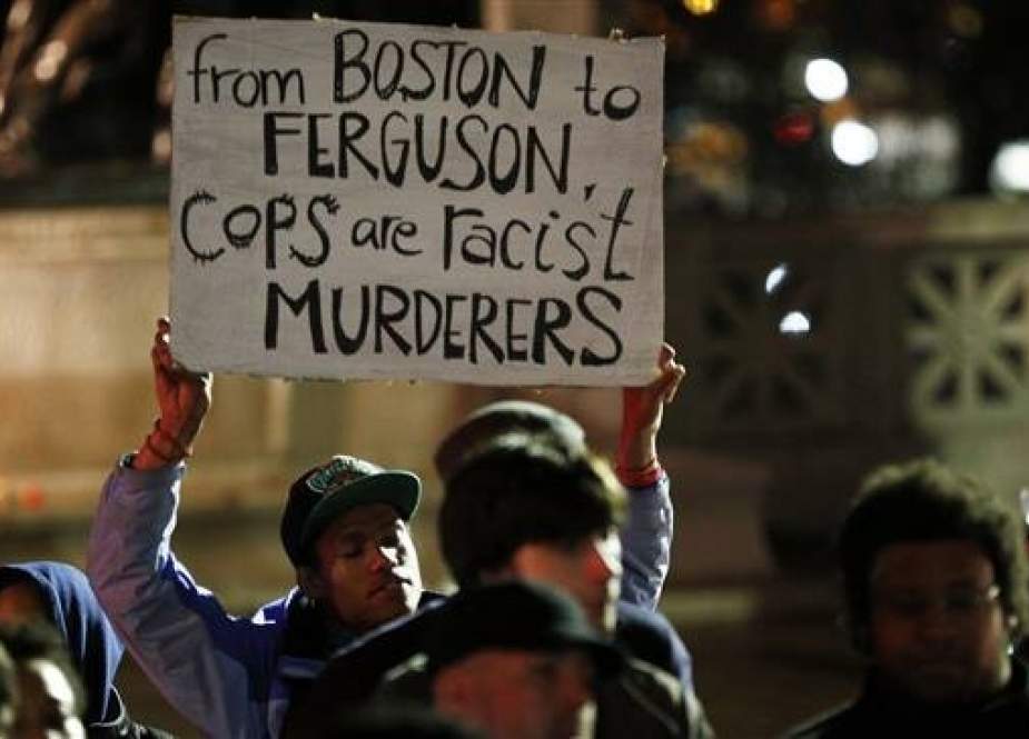 A man holds a sign in front of the State House in Boston, Massachusetts.jpg