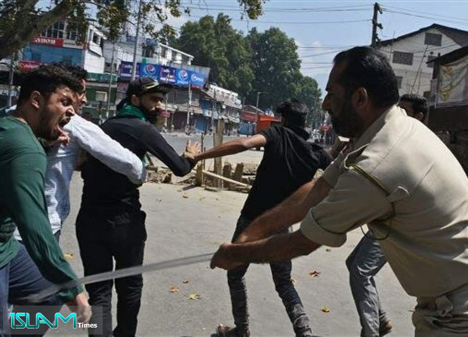An Indian policeman clashes with a Kashmiri man during a strict curfew in Lal Chowk area of Srinagar on the 8th day of Muharram on September 8, 2019