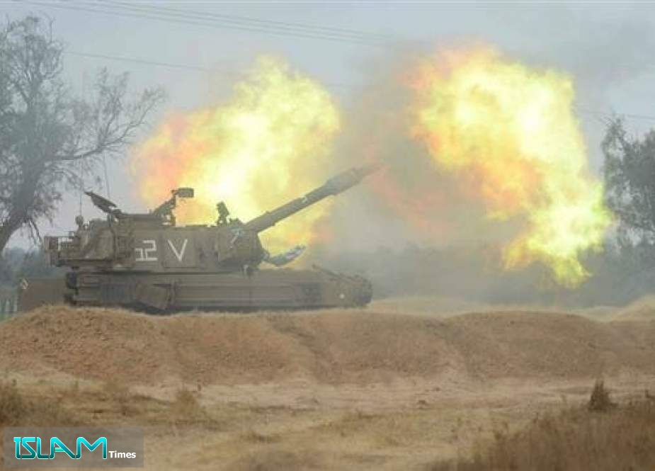 Israeli military artillery piece fires toward the Gaza Strip.
