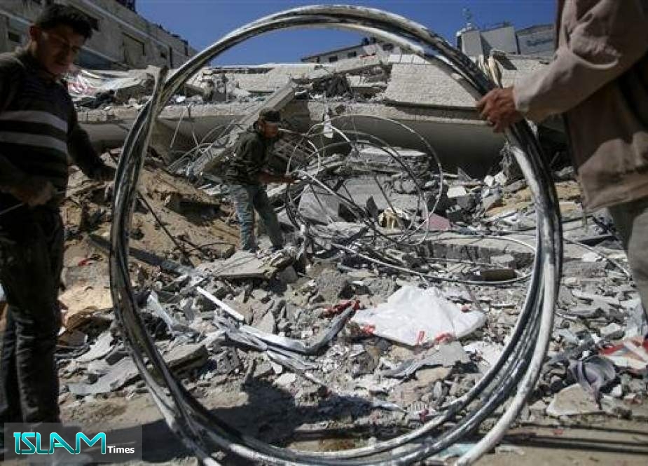 Palestinians in Gaza Strip sift through the rubble of a building destroyed during an Israeli airstrike