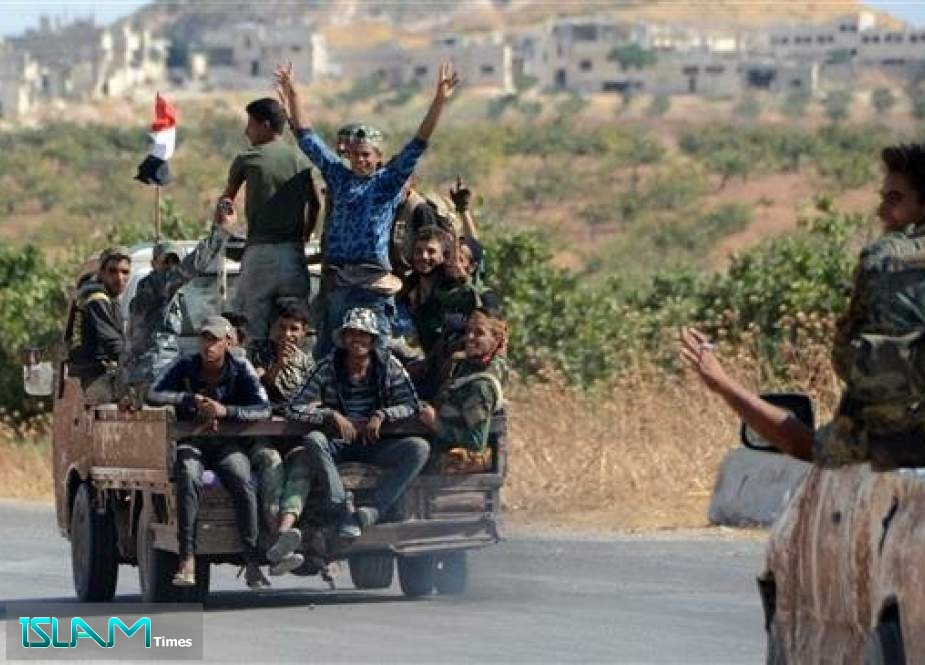 Members of the Syrian government forces are transported in the back of military vehicles toward the town of Khan Shaykhun in the northern Idlib province on August 24, 2019, after they announced the total control of the city a day before.