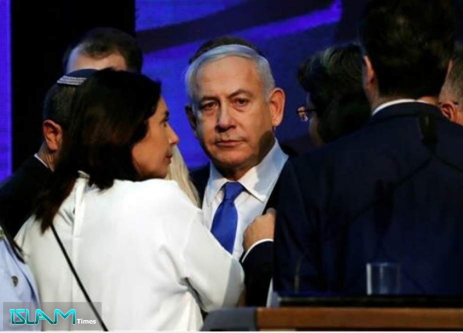 Israeli Prime Minister Benjamin Netanyahu (center) looks on after speaking to supporters at his Likud party headquarters following the announcement of exit polls during Israel