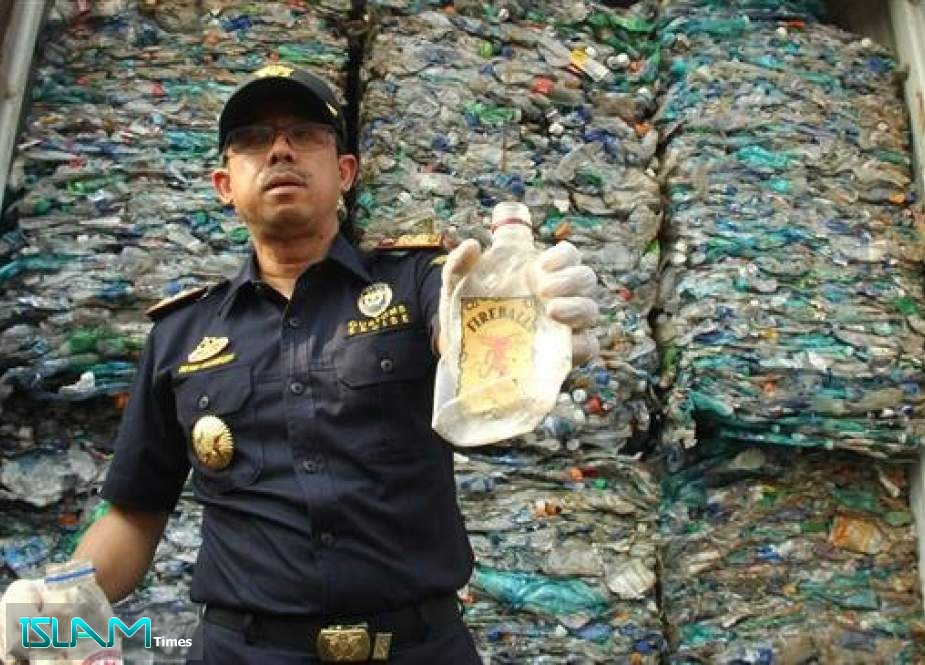 An Indonesian custom officer shows plastic waste from a container at the Jakarta international seaport, on September 18, 2019.