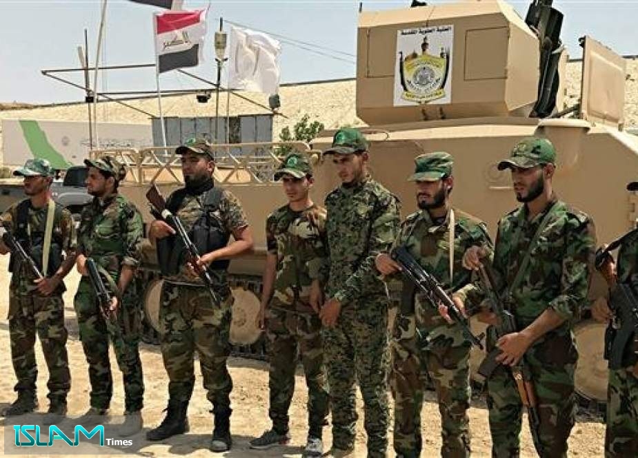 The file photo shows volunteer fighters from the Imam Ali Brigade, an armed faction with the Iraqi Popular Mobilization Units, at their camp in the holy city of Najaf, Iraq.