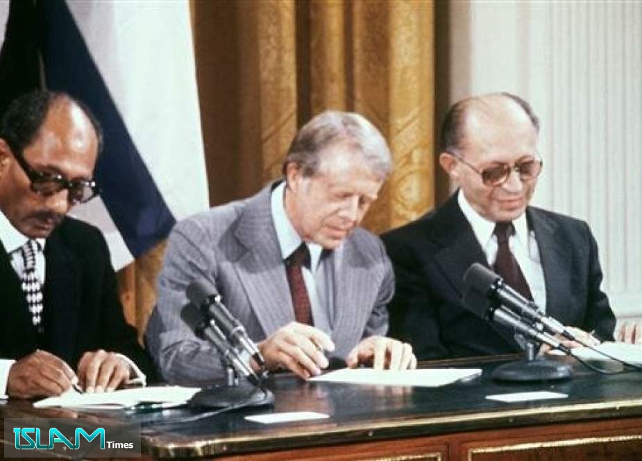 In this file photo taken on September 17, 1978 Egyptian President Anwar al-Sadat (L), Israeli Premier Menachem Begin (R) and US President Jimmy Carter (C) sign a peace agreement in the East Room of the White House.