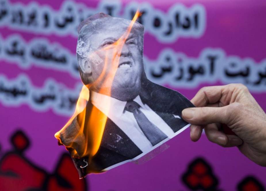 Menjelang sanksi baru Washington, seorang pemrotes Iran memegang gambar Donald Trump di luar bekas kedutaan besar AS di ibukota Iran Tehran pada 4 November 2018. (Foto: Majid Saeedi / Getty Images)