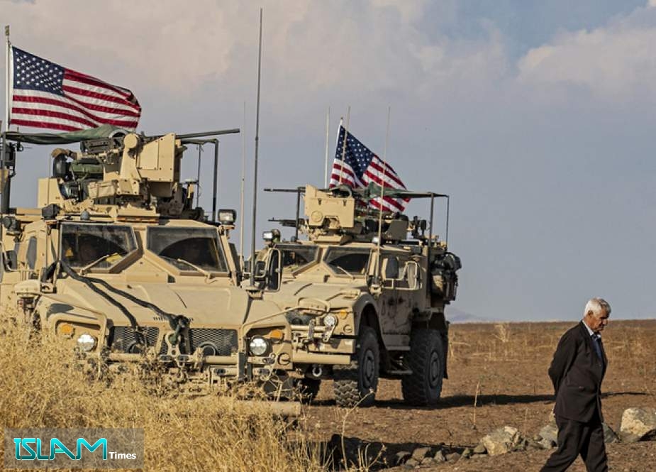 A Syrian man walks on as US armoured vehicles patrol the northeastern town of Qahtaniyah at the border with Turkey, on October 31, 2019. ©  AFP / Delil SOULEIMAN