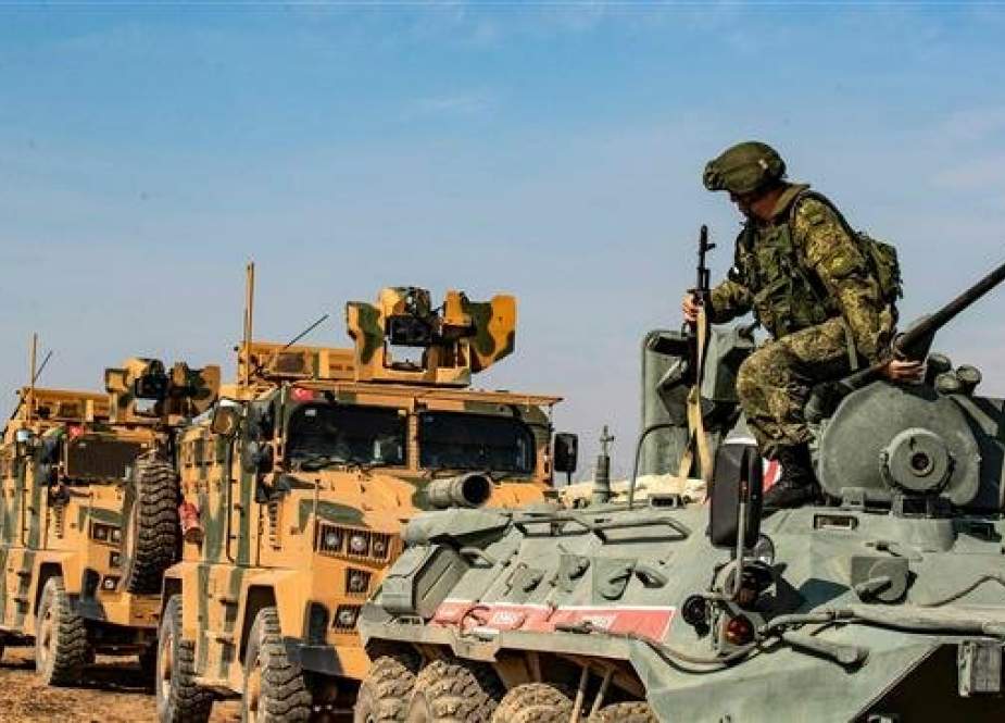 Turkish and Russian military vehicles drive on a joint patrol in the countryside of Darbasiyah town in Syria.jpg