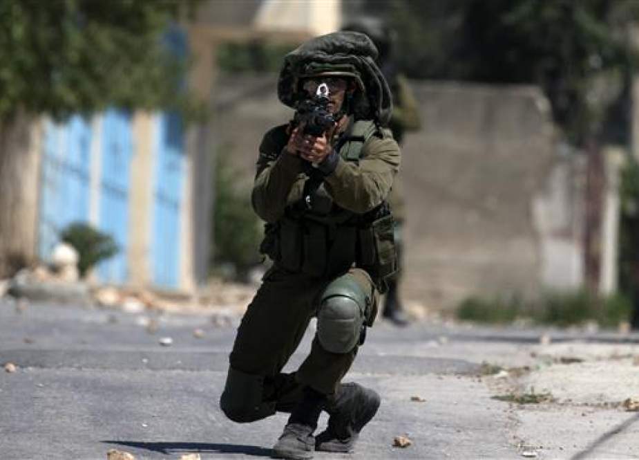 Israeli soldier takes aim at Palestinian protesters.jpg
