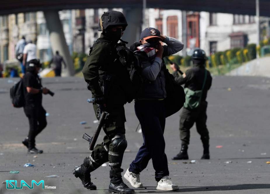 Police detain a backer of former President Evo Morales after they launched tear gas at a massive funeral procession that was marching into La Paz, Bolivia,