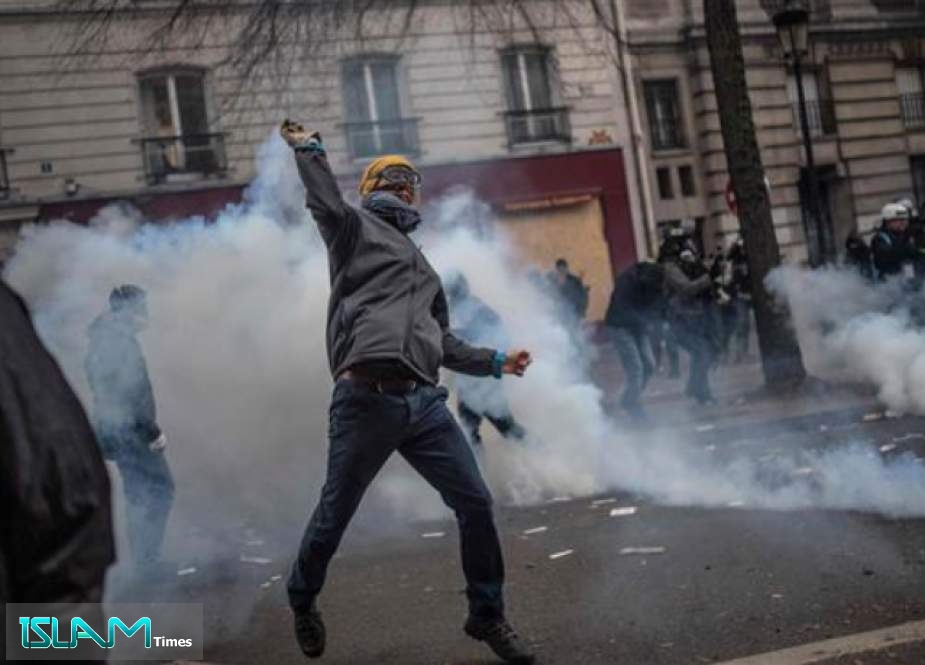 A protestor throws a tear gas canister back to the police during a protest rally in Paris, on December 5, 2019. (Photo by AFP)