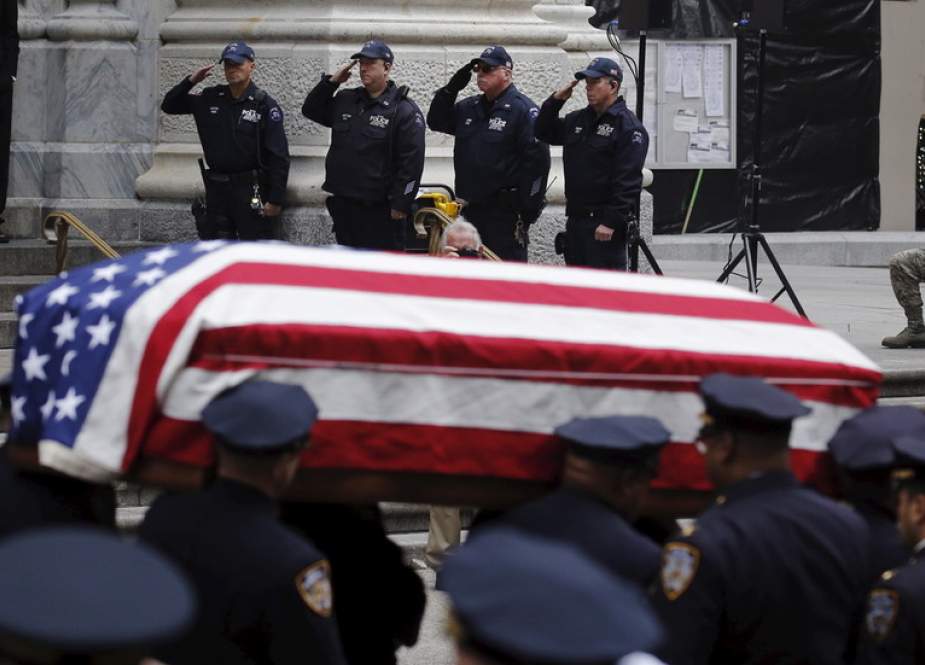 NYPD officers salute during the funeral.JPG