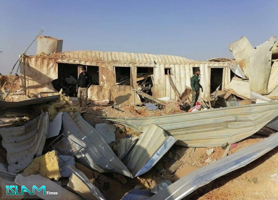 Fighters from the Kataeb Hezbollah militia inspect the destruction of their headquarters on Monday in the aftermath of a U.S. airstrike in Qaim, Iraq.