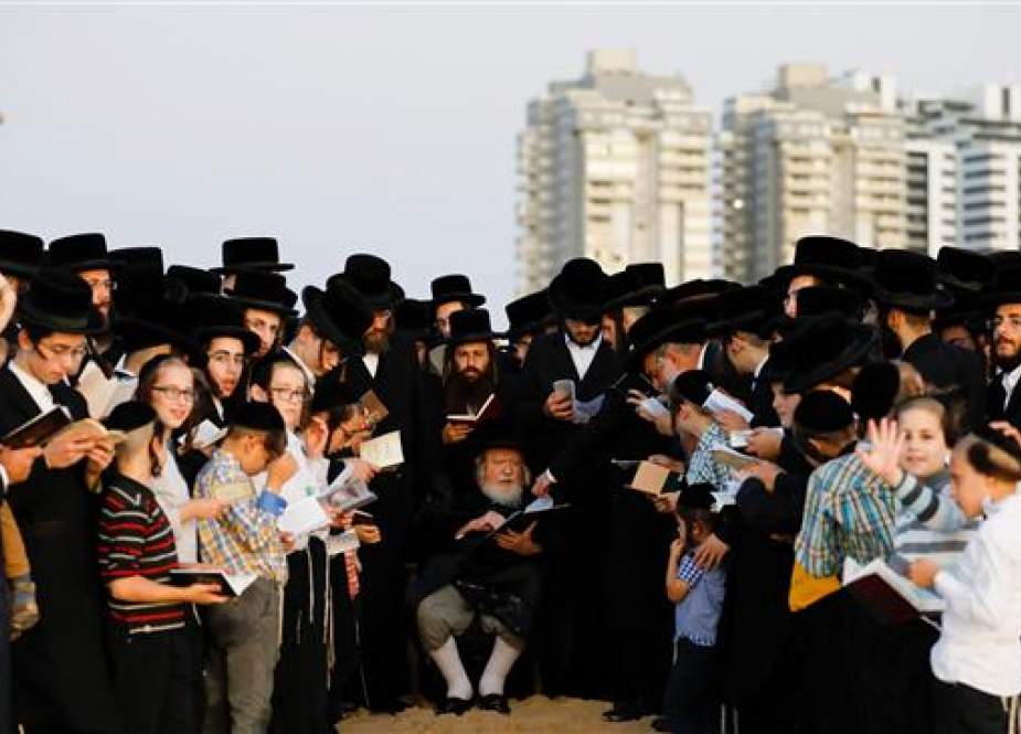 Ultra-Orthodox Jewish men surround their rabbi.jpg