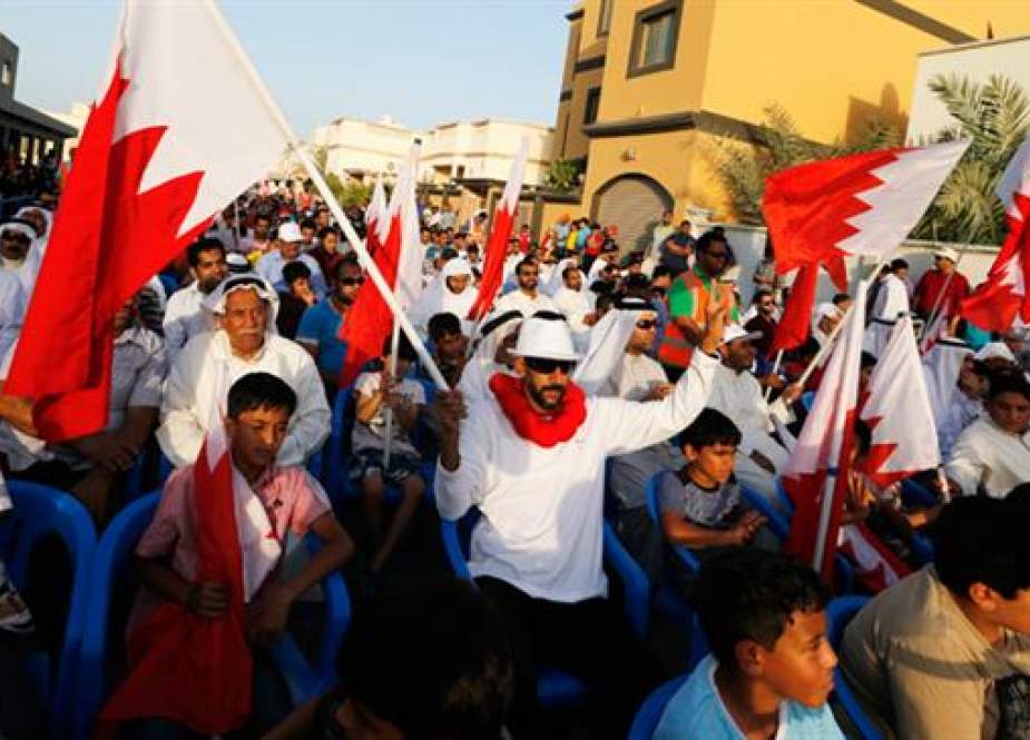 Bahrain protester waves a Bahraini flag as he flashes a victory sign.jpg