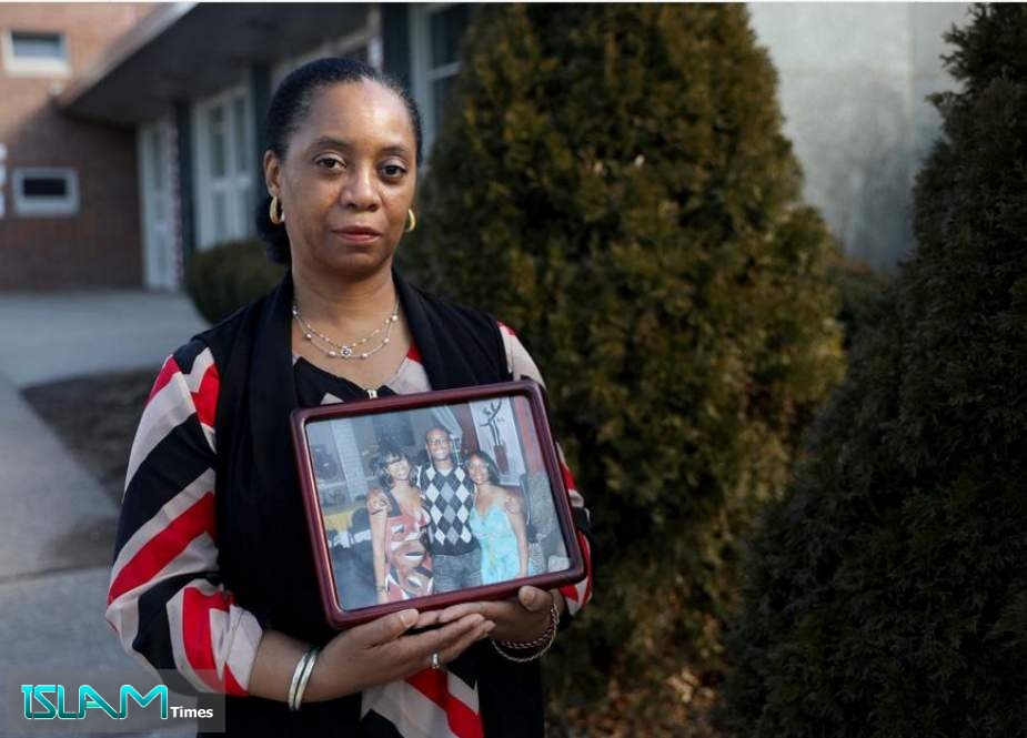 Rosalind Williams, mother of U.S. Army veteran Corey Hadley, stands for a portrait outside Northeast High School, where she teaches science, in Philadelphia on Wednesday, Jan. 29, 2020. Williams believes that Hadley took his own life Jan. 2 as a result of traumatic brain injury suffered during combat. She is holding a photograph of herself and her son with a family friend.