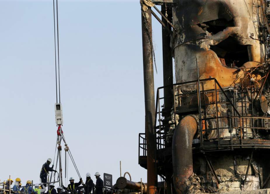 Workers are seen at the damaged site of Saudi Aramco oil facility in Abqaiq, Saudi Arabia.JPG