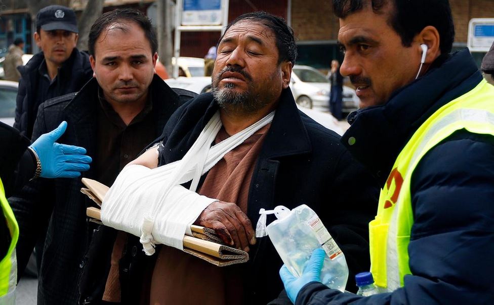 Afghan health workers carry a wounded man from a hospital after gunmen attacked a political gathering in Kabul. EPA