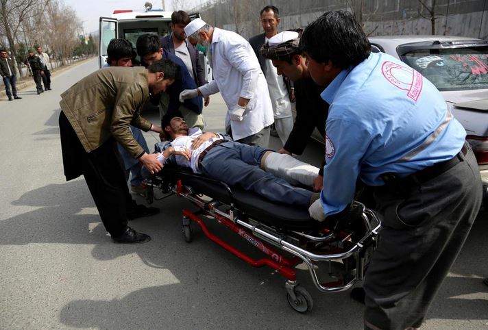 An injured man is carried into an ambulance after an attack in Kabul