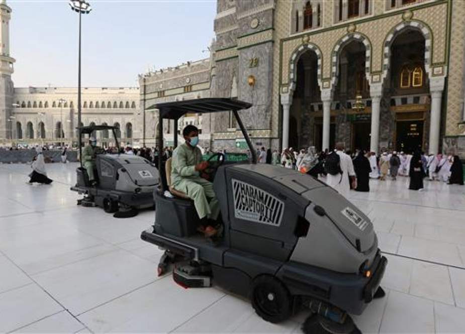Labourers wearing masks clean the floor of the Grand Mosque in Saudi Arabia..jpg