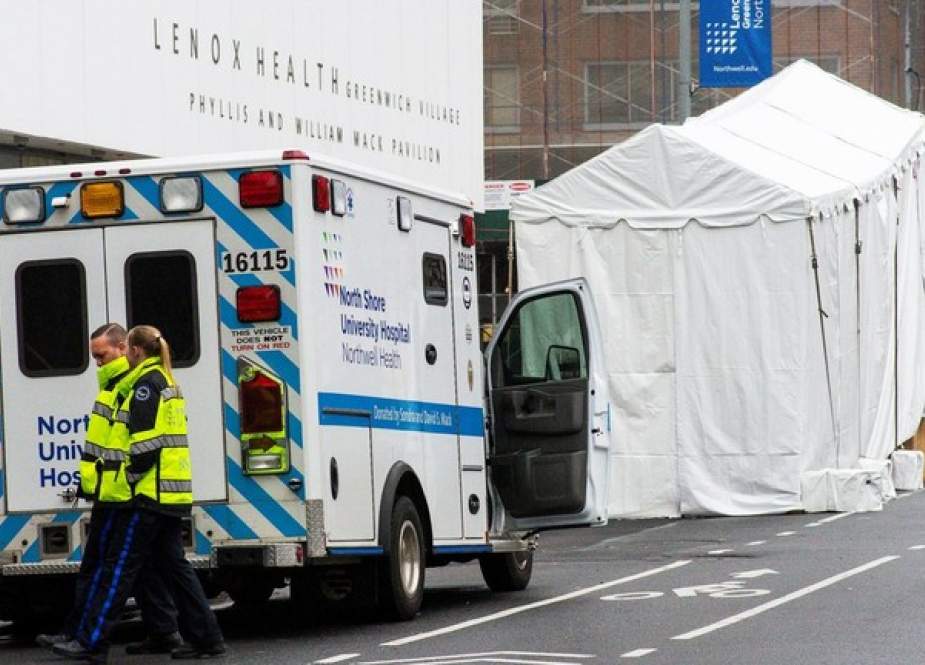 Paramedics walk by a makeshift morgue set outside Lenox Health Medical Pavilion in New York.JPG