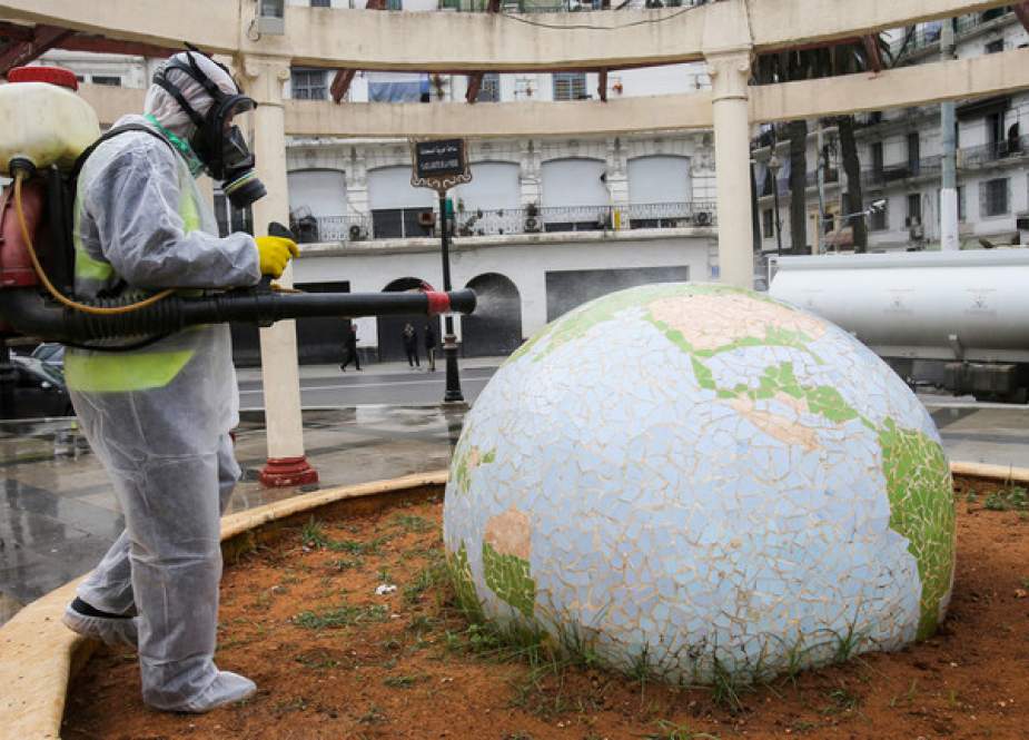 A worker wearing a protective suit disinfects a globe-shaped public garden in Algiers, Algeria.JPG