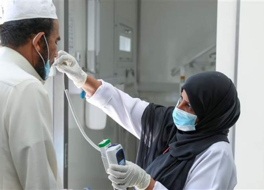 Saudi nurse checks temperature for the residents of Ajyad Almasafi district in the holy city of Mecca.jpg