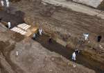 Workers in full Hazmat suits bury rows of coffins in mass grave  <img src="https://www.islamtimes.org/images/picture_icon.gif" width="16" height="13" border="0" align="top">