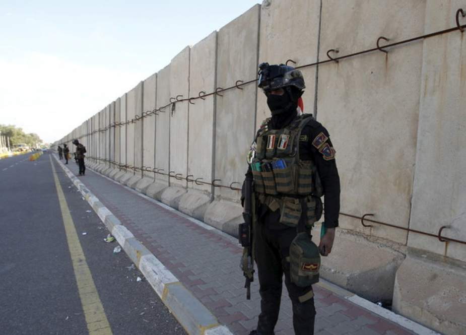 Iraqi security forces stand guard near the gates of Baghdad