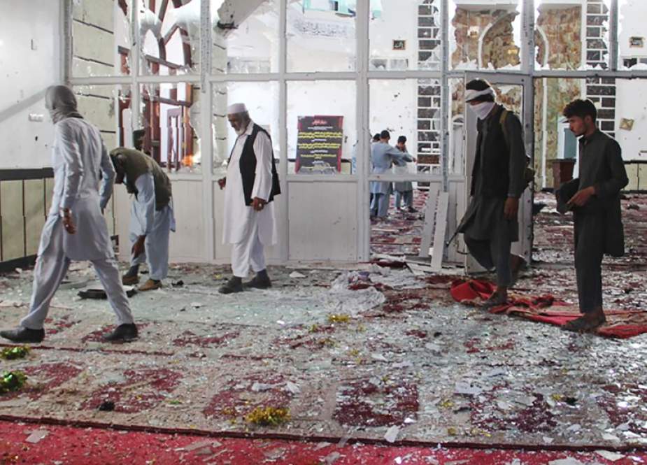 Afghan residents walk inside a damaged mosque after an attack.jpg