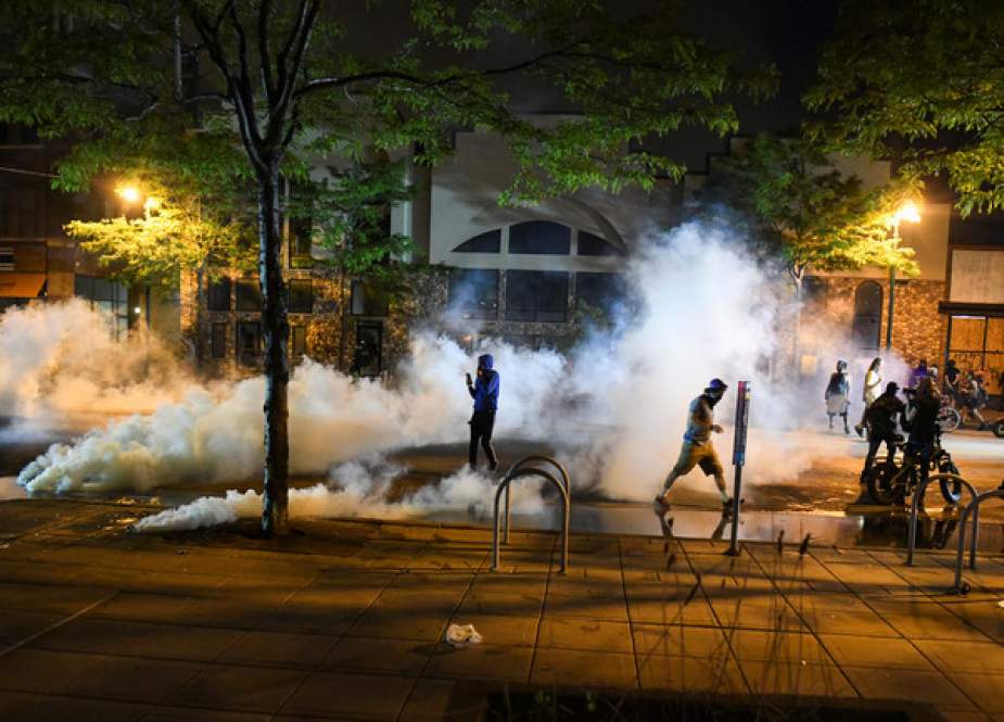 Protesters run from tear gas near the Minneapolis Police third precinct, Minnesota, US.JPG