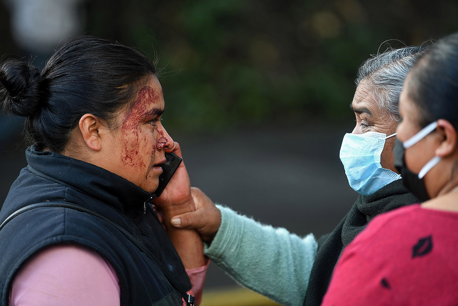 A relative of a passerby who was killed in an attack speaks on the phone at the crime scene in Mexico City on June 26. Mexico City’s Public Security Secretary Omar García Harfuch, who was targeted, was wounded in the attack. PEDRO PARDO/AFP via Getty